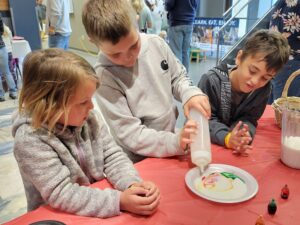 Three kids do a milk science experiment